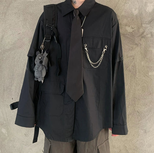 黒のネクタイ付きシャツの正面詳細(首から下)。ネクタイと胸元のチェーン装飾。