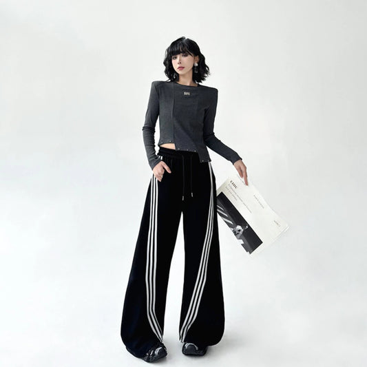 黒のスポーティーなワイドパンツを着用した全身正面。裾にたまるボリューム感のあるシルエット。