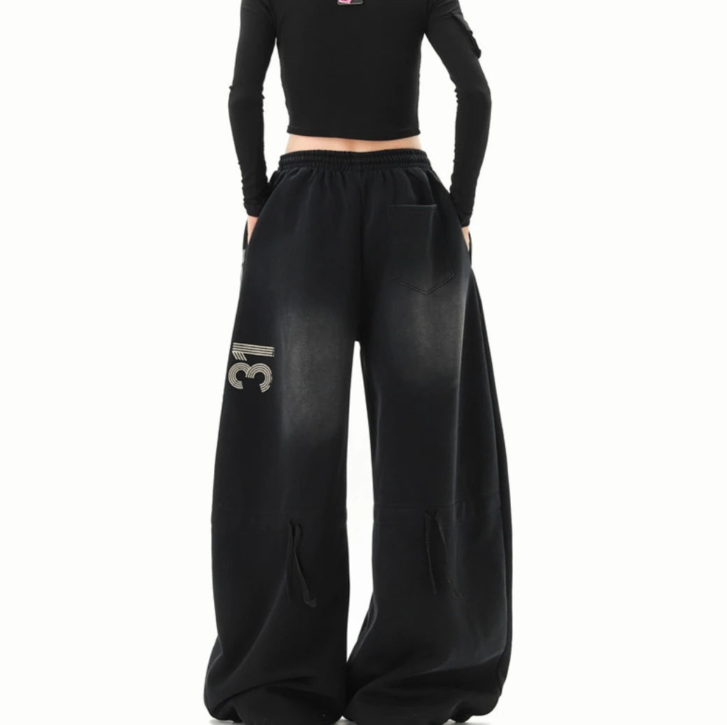 黒のワイドスウェットパンツを着用した後ろ姿。右太ももに「31」の数字ロゴが入っている。