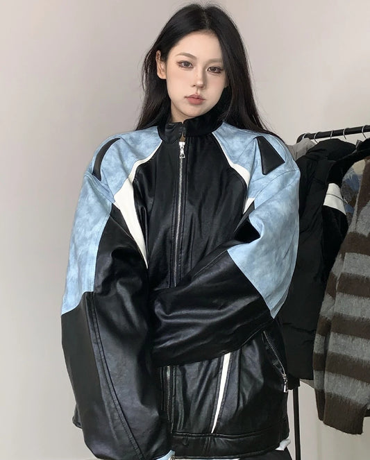 ブルーとブラックの配色ライダースジャケットを着たモデル。腕組みポーズ。