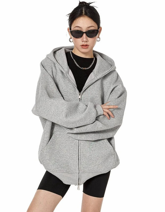 グレーのオーバーサイズジップパーカーをフルジップで閉め、腕を組んだモデルの正面上半身ショット