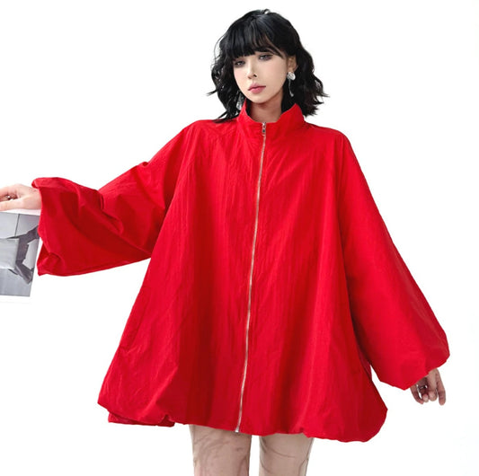 赤色のオーバーサイズジップアップアウターを着用したモデルの正面。広がる袖と裾のデザインが際立つ。