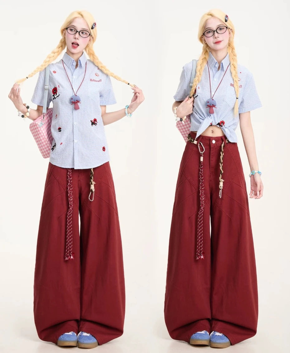 おさげ髪(三つ編み)を持ったポーズの正面写真。ワインレッドのパンツが主役のカジュアルガーリーなスタイル。