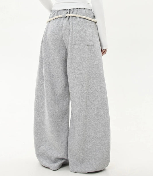 ロングの白ロープ紐が垂れたグレーワイドスウェットパンツの背面ショット。裾までたっぷりとボリュームのあるシルエットが特徴。