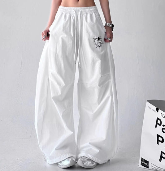 フロントスタイルの白いワイドパンツ。左ポケット付近にある『Lucky』という文字が入ったハートの刺繍が特徴。