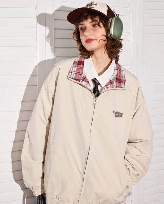 アプリコットカラー側のリバーシブルジャケットを着たモデル。チェック柄の襟元が見える。