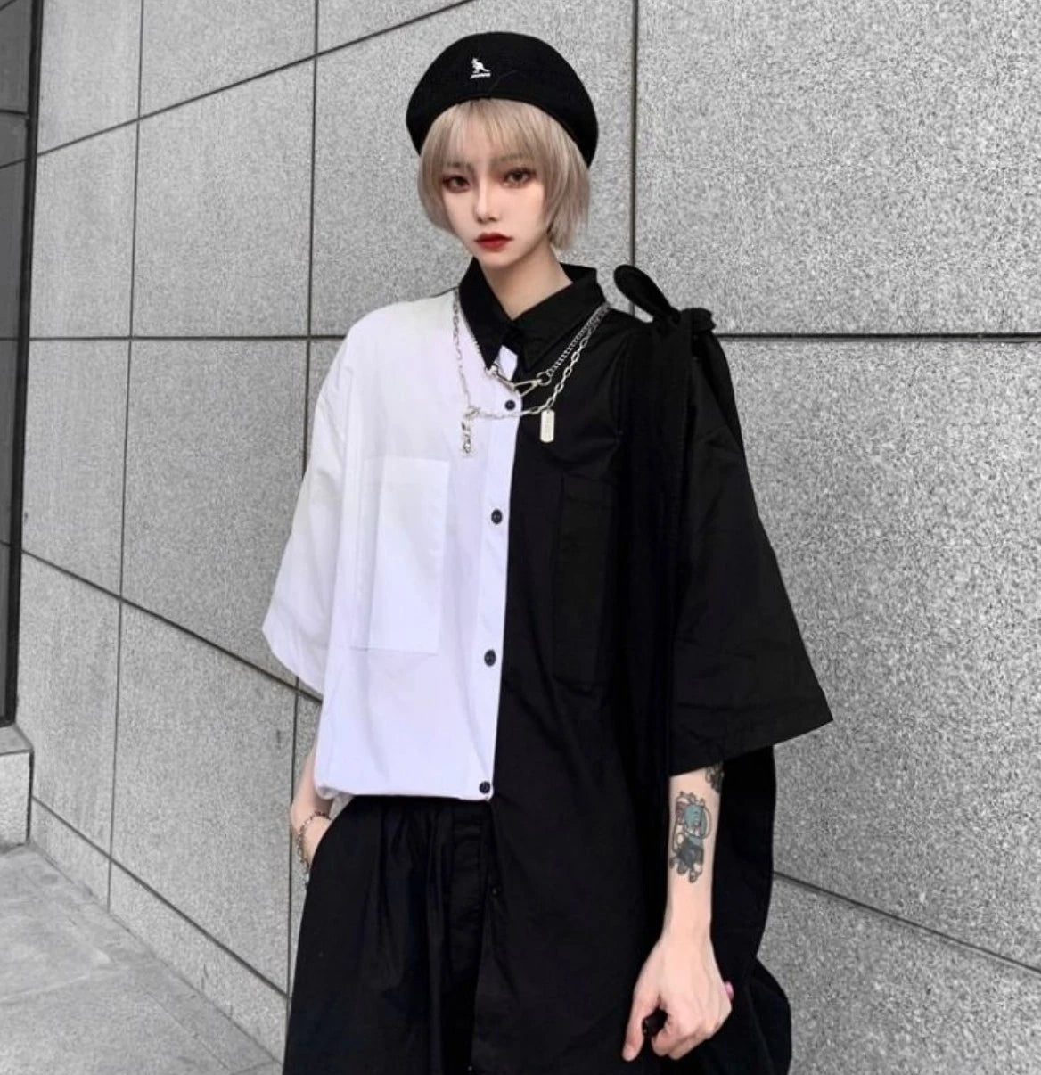 白と黒のバイカラーシャツを着たモデル。ベレー帽を被り、正面を見ている立ち姿。