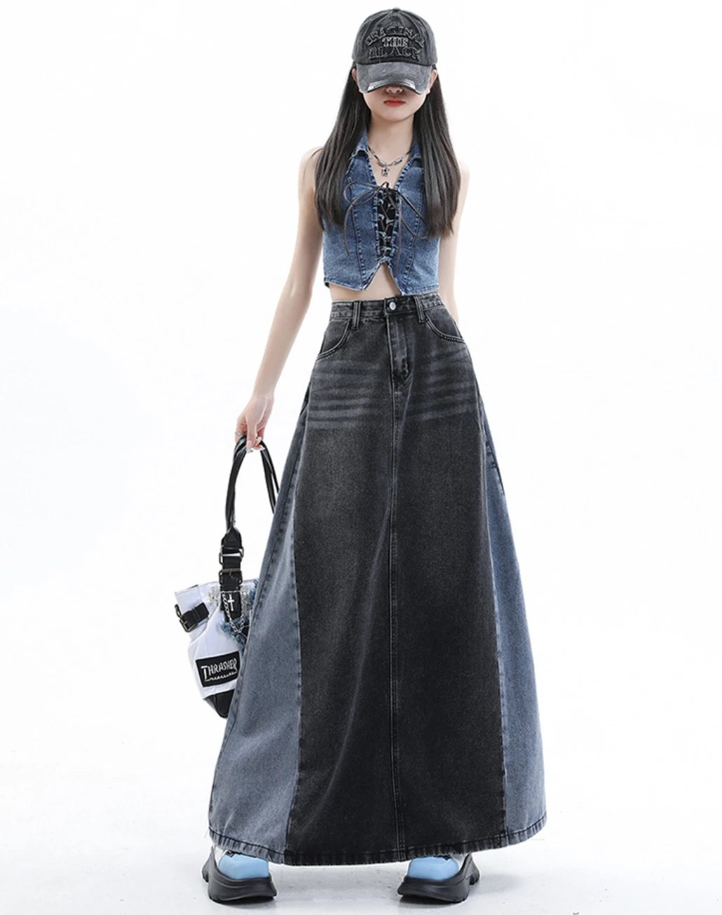 黒のロングデニムスカートを着たモデル。正面立ち姿。白いバッグを手に提げている。