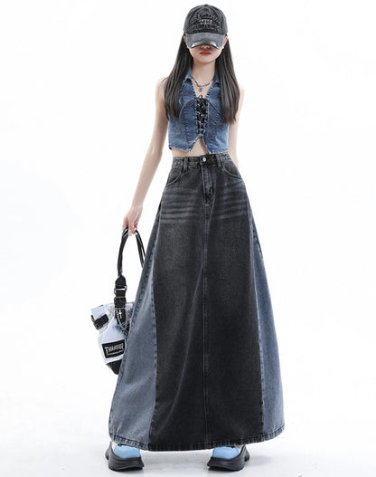 黒のロングデニムスカートを着たモデル。正面立ち姿。白いバッグを手に提げている。