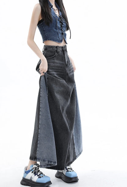 黒のロングデニムスカートを着たモデル。スカートの両端を指でつまみ、生地の広がりを見せるポーズ。