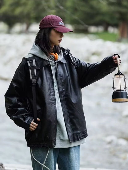 黒のオーバーサイズレザージャケットとパーカー。ランタンを持つアウトドアスタイル。