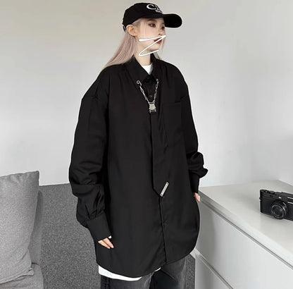 黒のオーバーサイズシャツを着用した正面の立ち姿。シルバーのチェーンアクセサリーが黒地に映えるクールな印象。