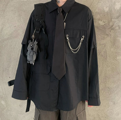 黒のネクタイ付きシャツの正面詳細（首から下）。ネクタイと胸元のチェーン装飾。