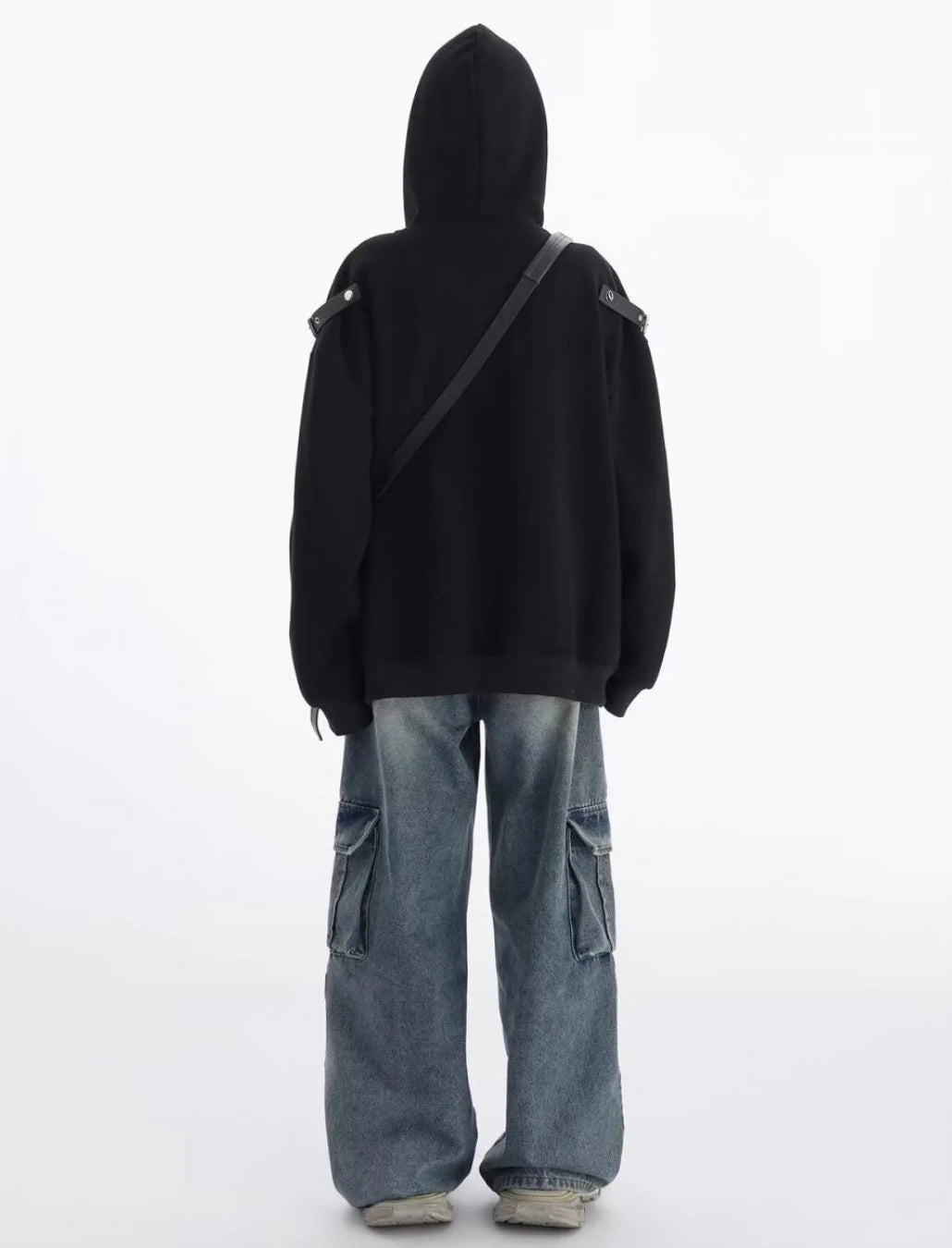 黒のショルダーベルト付きオーバーサイズパーカーを着た後ろ姿。フードと肩ベルトの位置が分かるバックスタイルコーデ。
