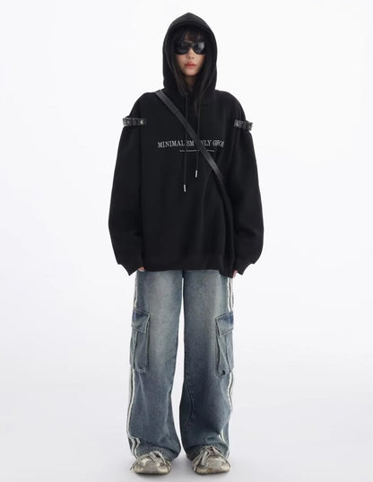 黒のショルダーベルト付きオーバーサイズパーカーとワイドカーゴデニムの正面全身コーデ。シンプルに着こなしたストリートスタイル。