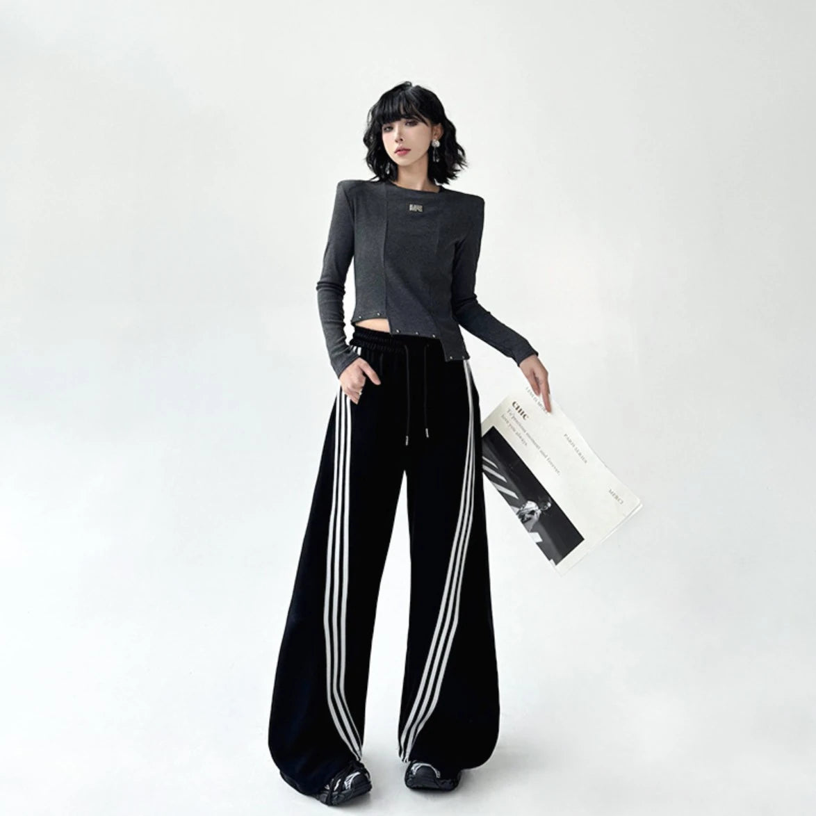 黒のスポーティーなワイドパンツを着用した全身正面。裾にたまるボリューム感のあるシルエット。