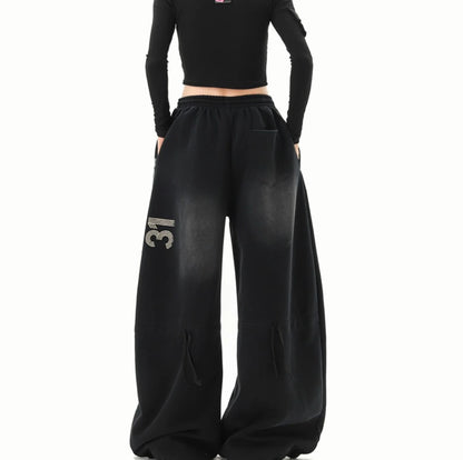 黒のワイドスウェットパンツを着用した後ろ姿。右太ももに「31」の数字ロゴが入っている。