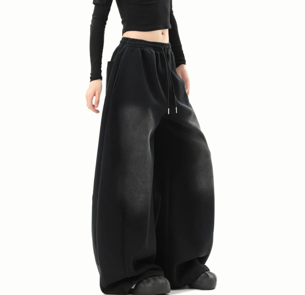 黒のワイドスウェットパンツを着用した斜め前からの全身写真。色落ち加工とワイドシルエットが特徴。