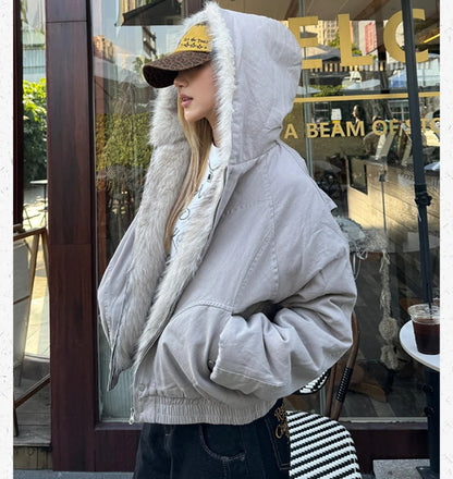 ファー付きのフードを被り、横向きで立ちポーズをとる女性。ブルゾンの袖のボリューム感がわかるカット。