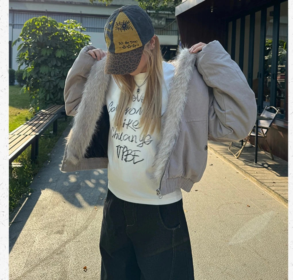 ファーの裏地を見せながら、フードを被らずキャップを直す女性。屋外で撮影。