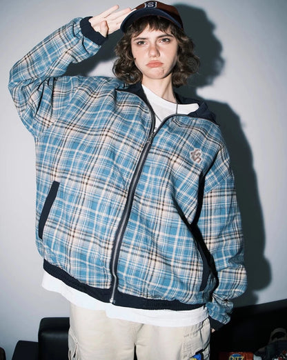 ブルーチェック柄側のリバーシブルジャケットを着たモデル。敬礼ポーズ。