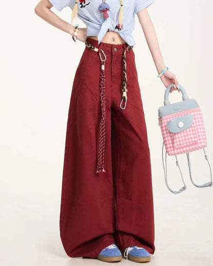 パンツの腰回りと太もも部分のクローズアップ。特徴的な切り替えラインと、手に持ったピンクのチェック柄バッグ。