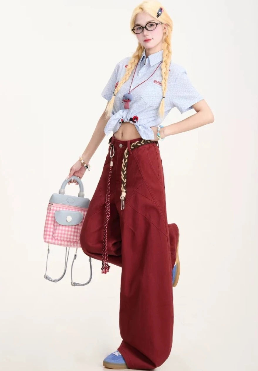 片足を上げてポーズをとるモデル。パンツの動きやすさと、サイドのステッチデザインを強調したショット。