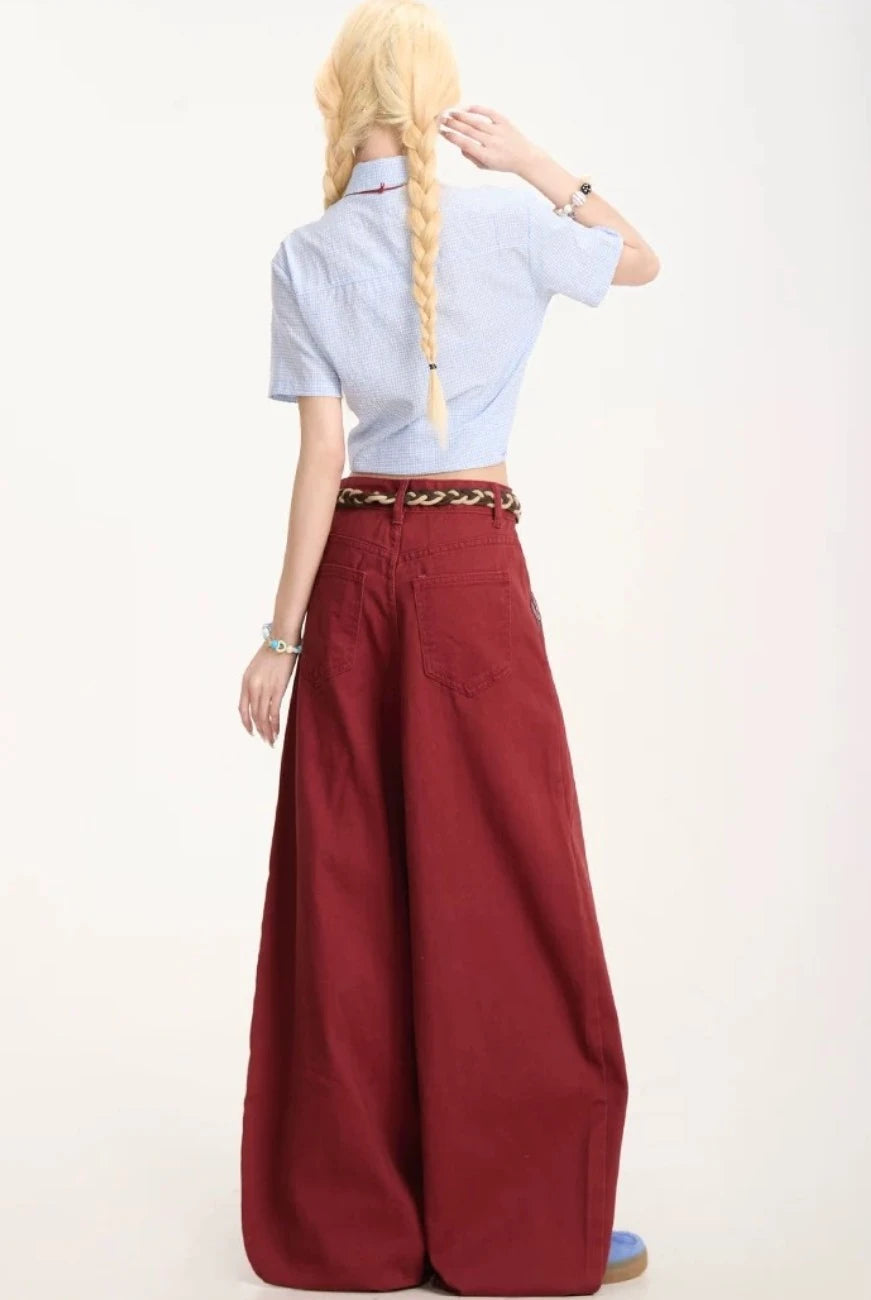 ワインレッドのワイドパンツを着用した後ろ姿の全身写真。ヒップから裾にかけてのボリューム感とドレープ。