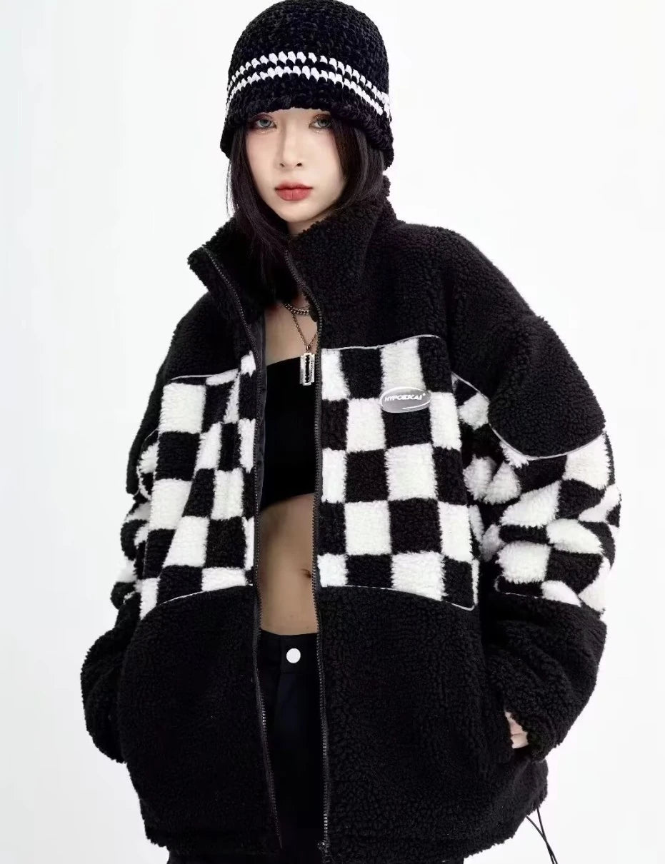 白と黒のチェッカーボード柄ボアフリースジャケット。ジップを閉めた正面写真。お揃いのニット帽を合わせたストリートスタイル。