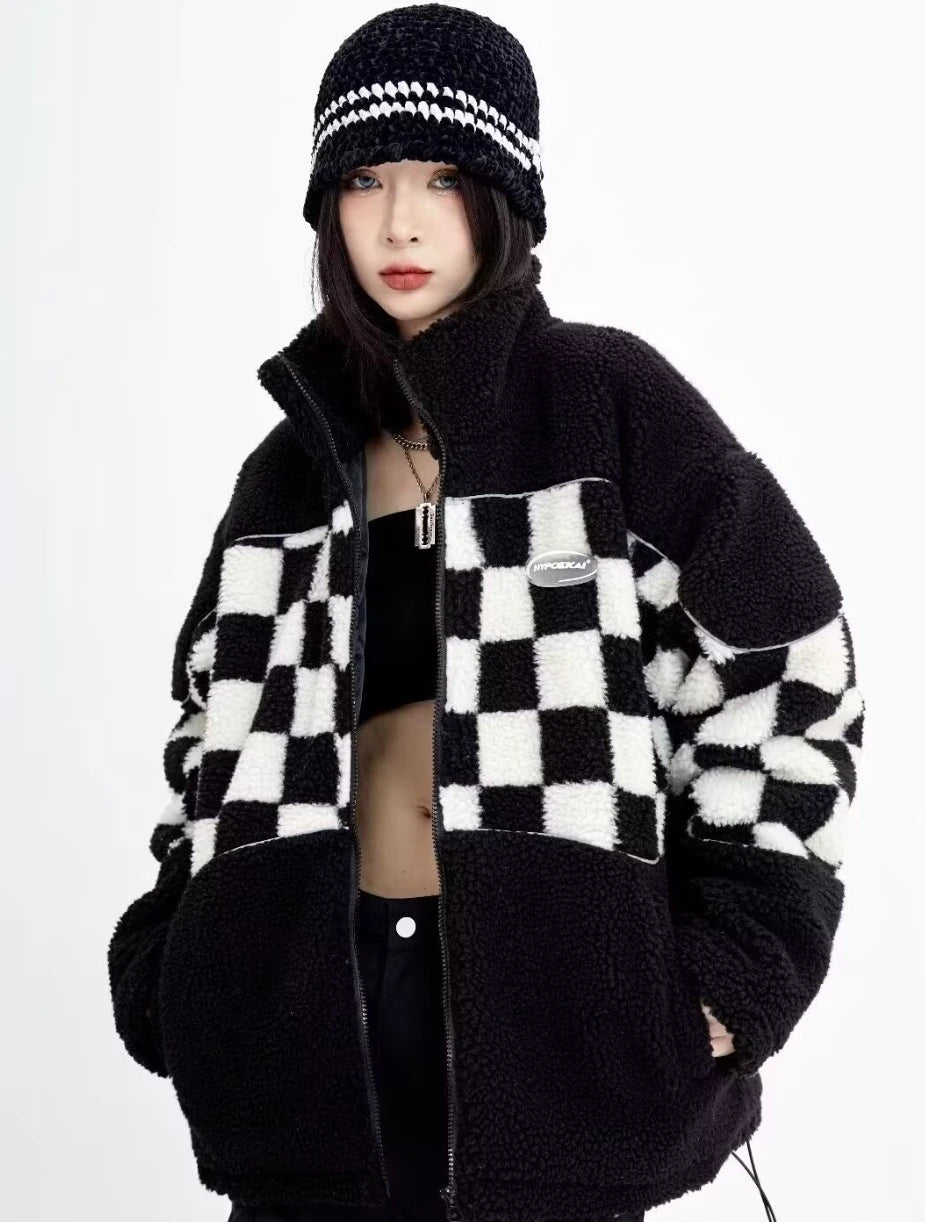 ファスナーを開けた状態のチェッカーボード柄シェルパジャケット。黒いインナーを見せたレイヤードスタイル。