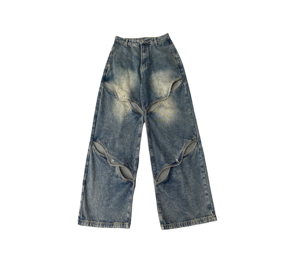 白背景に平置きしたカットアウトワイドデニムパンツのフロント全体画像。脚部分に並ぶカットアウトスリットデザインがはっきり分かる。