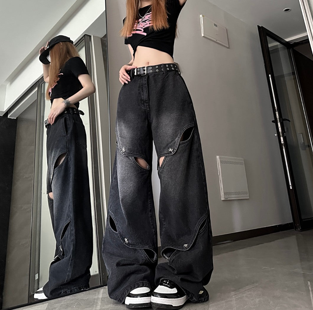 鏡越しに横から撮影したブラックのカットアウトワイドデニムパンツ。脚のラインに沿ったレイヤードスリットとゆるいシルエットが分かるスタイリング写真。