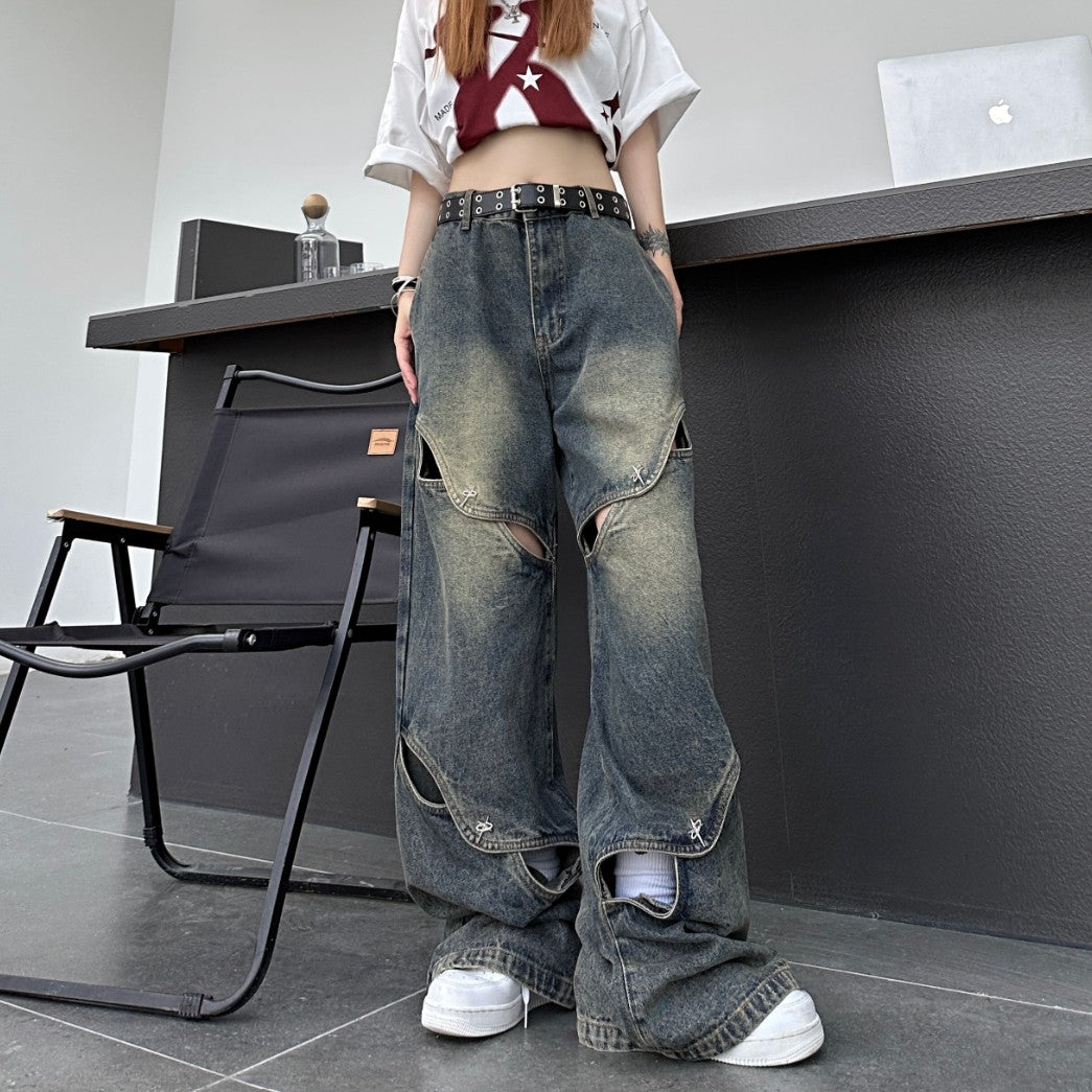 裾の一部スリットが少し開いた状態のカットアウトワイドデニムパンツ正面ショット。ゆるいワイドシルエットとダメージ感が伝わる。