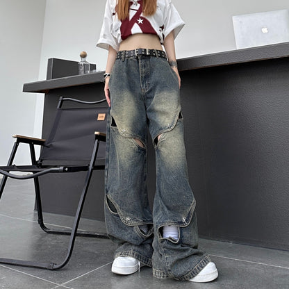 裾の一部スリットが少し開いた状態のカットアウトワイドデニムパンツ正面ショット。ゆるいワイドシルエットとダメージ感が伝わる。