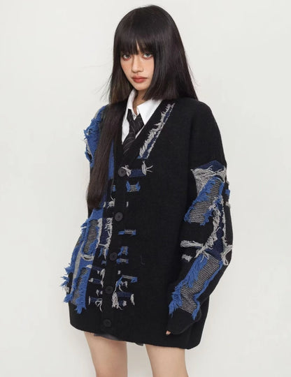 ブラック×ブルーのダメージカーディガンを着用した斜め前からのアングル。袖やボディの激しいクラッシュ加工が際立つデザイン。