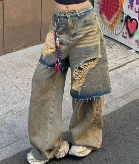 大きなダメージ加工と色落ちが特徴のオーバーサイズデニムパンツ。カラフルなキーホルダーがアクセント。