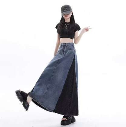 グレーのロングデニムスカートを着たモデル。キャップを被り、片足を上げてスカートの広がりを見せている。