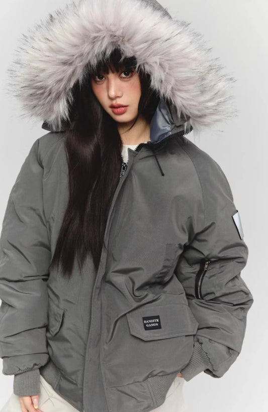 グレーのファー付きダウンジャケットのクローズアップ。フードのファーと左腕のポケットディテール。