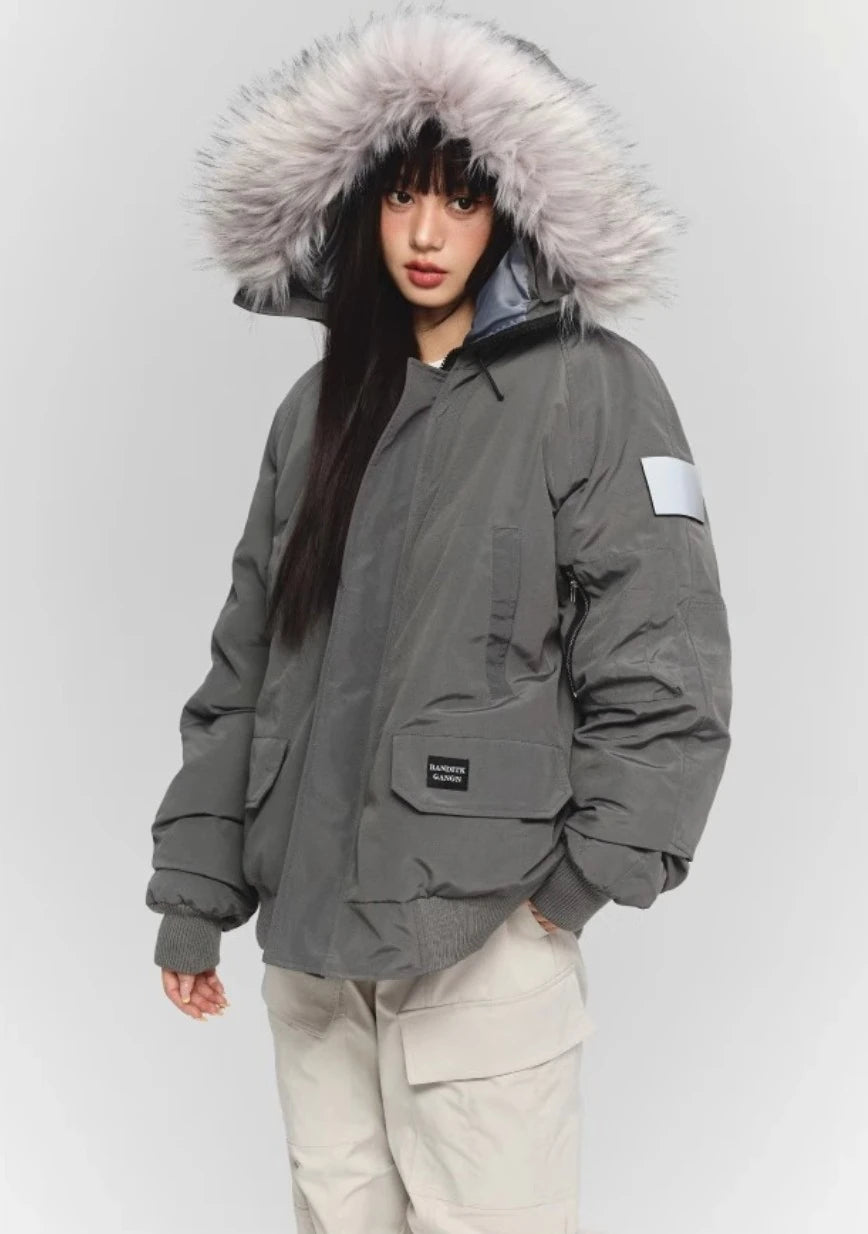 グレーのファー付きダウンとカーゴパンツの全身。左胸と袖に反射材のディテール。