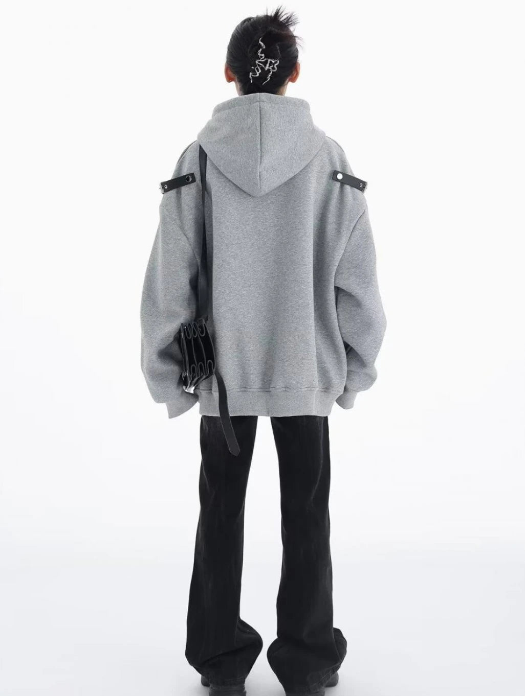 グレーのショルダーベルト付きオーバーサイズパーカーを着た後ろ姿の全身コーデ。肩ベルトとフードの位置が分かるバックスタイル。