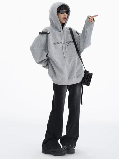 グレーのショルダーベルト付きオーバーサイズパーカーにブラックデニムを合わせたフード着用の全身コーデ。斜め掛けバッグを合わせたストリートスタイル。