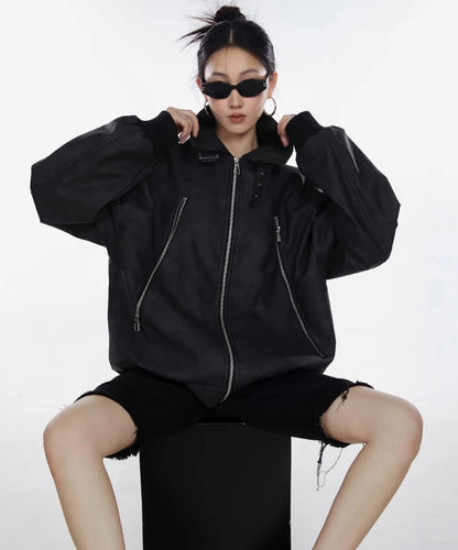 ブラックのオーバーサイズジャケットを着た女性が前を閉じて腰掛ける正面着用写真