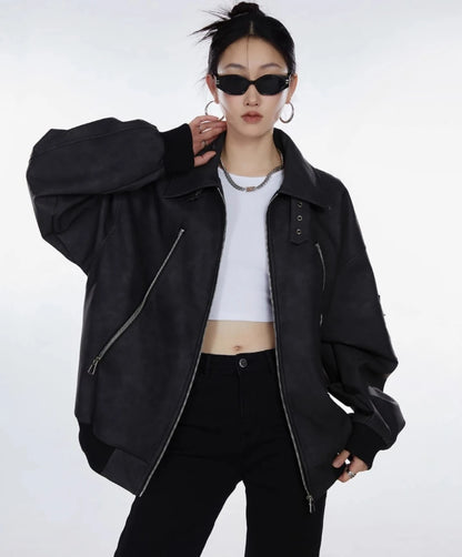 ブラックジャケットを前開きで羽織り白トップスを見せた女性のウエストアップ写真