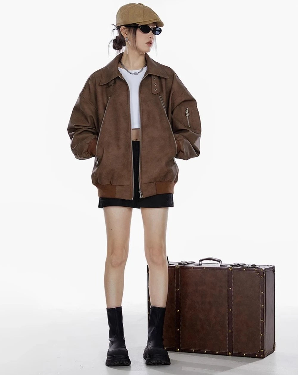 ブラウンジャケットと黒ミニスカートを合わせた女性の全身コーデ写真