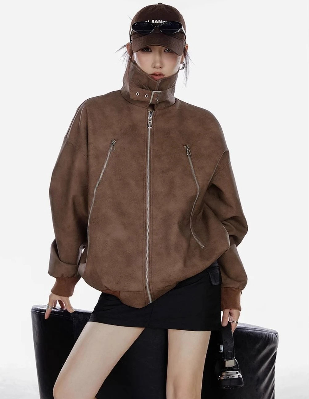 襟を立てたブラウンジャケットを着た女性が正面を向くコーディネート写真