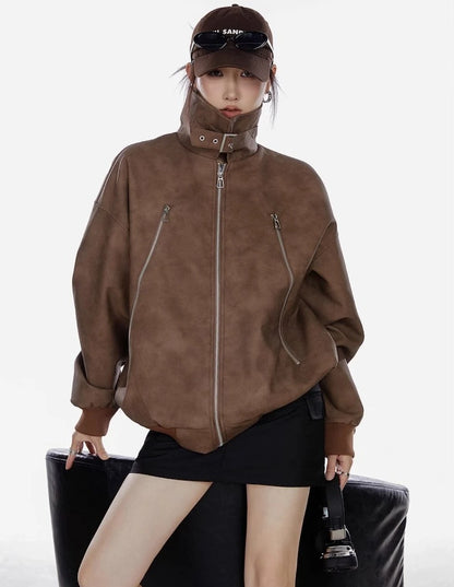 襟を立てたブラウンジャケットを着た女性が正面を向くコーディネート写真