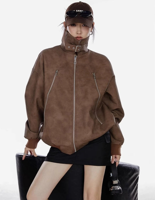 襟を立てたブラウンジャケットを着た女性が正面を向くコーディネート写真