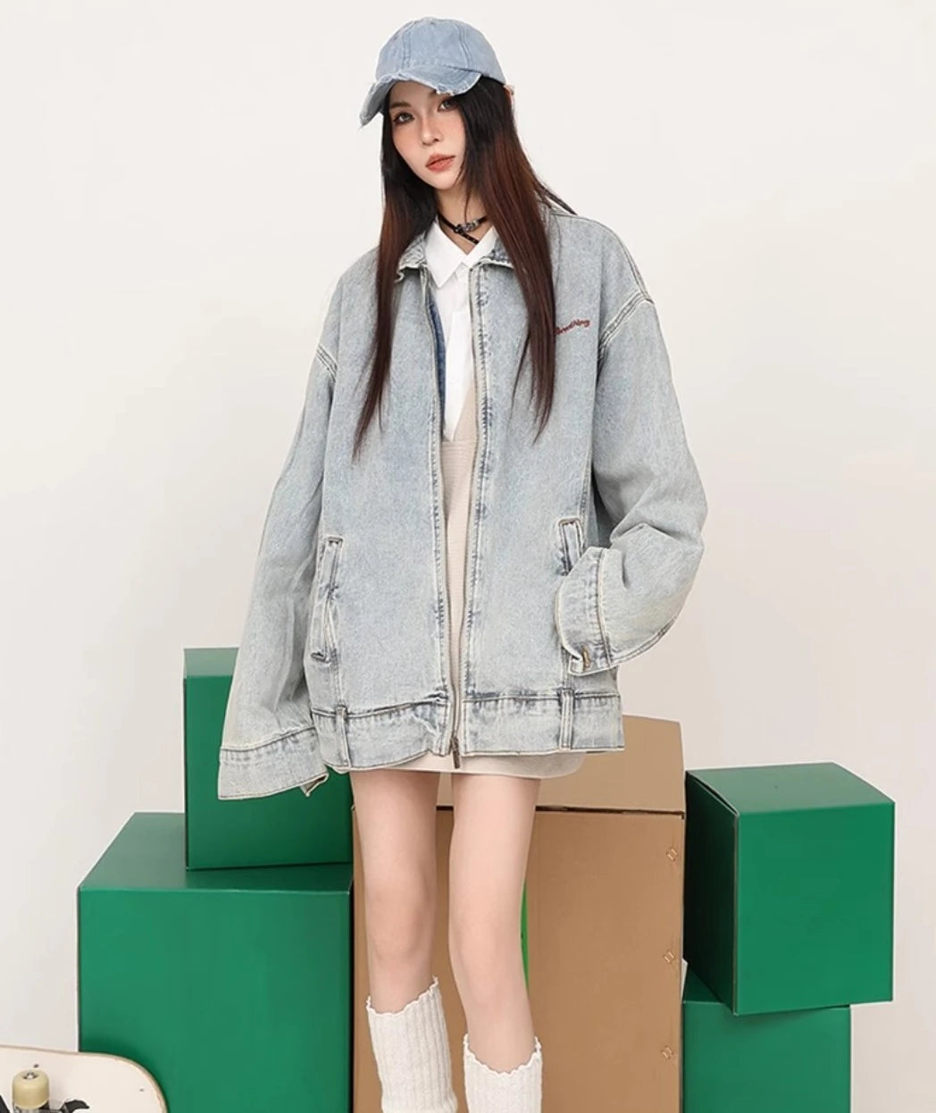 ライトブルーのデニムジャケットを着たモデル。段ボール箱の前で立ち姿。