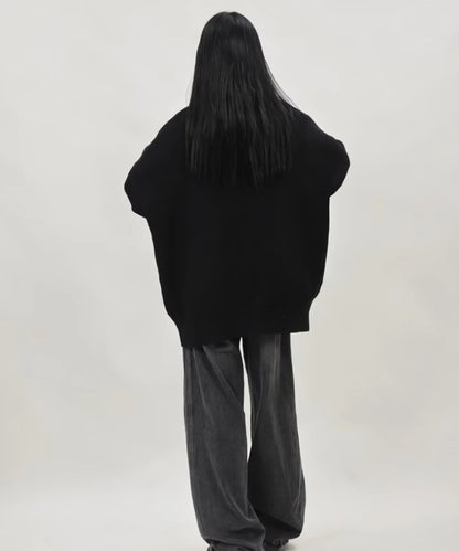 ブラックのオーバーサイズジップニットカーディガンを着たレディースモデルの後ろ姿とドロップショルダーのゆったりシルエット