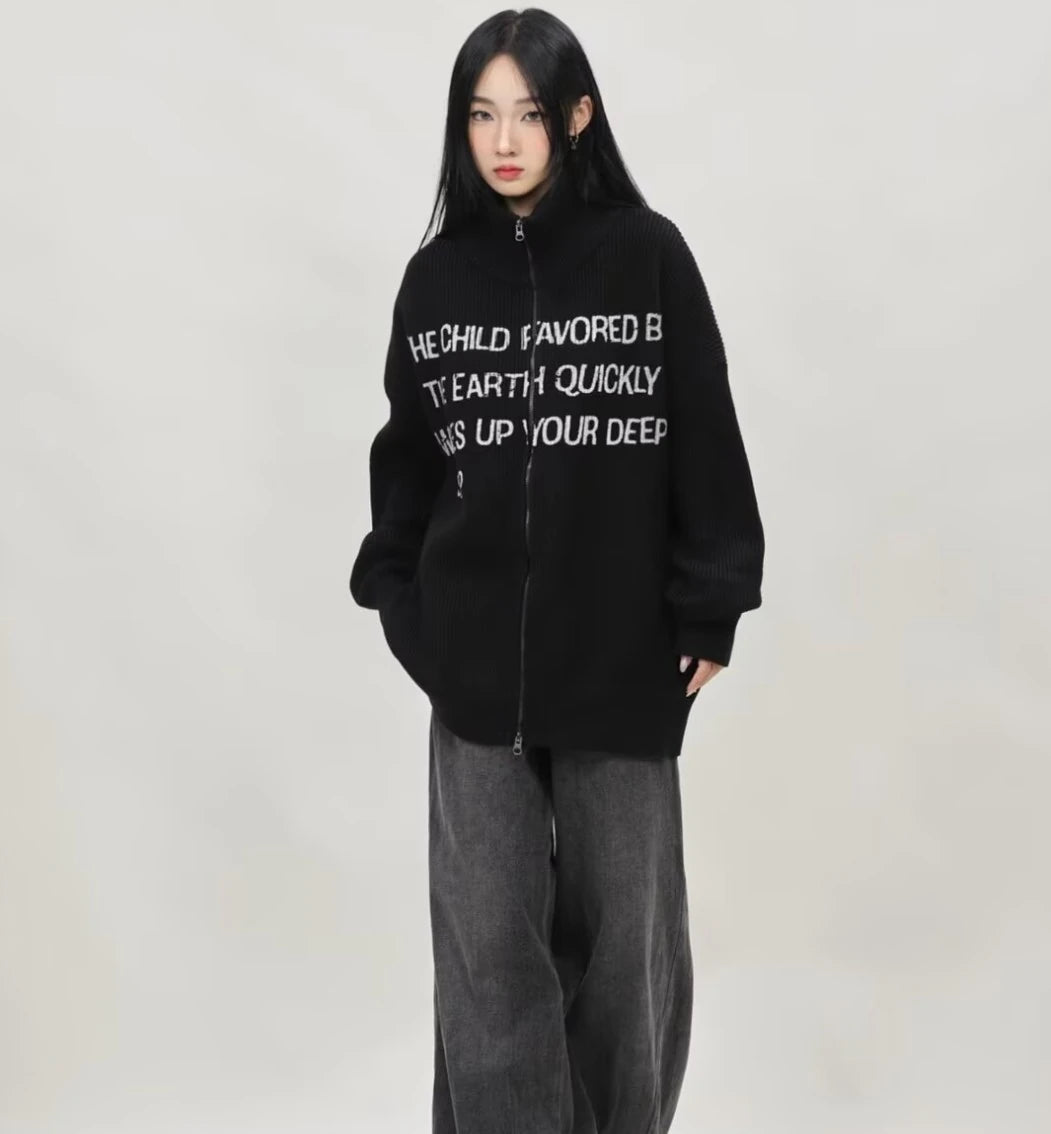 ブラックの英字メッセージジップニットカーディガンとグレーワイドデニムを合わせたレディースモデルの正面全身コーデ